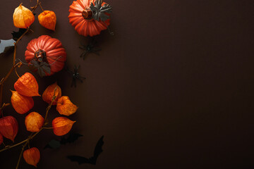 Halloween background. Flock of black bats and branch of dry orange flowers for Halloween. Black...