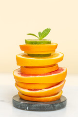 Slices of citrus fruits are stacked on top of each other on a stone stand