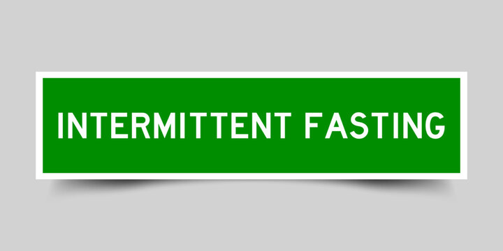 Green color square shape sticker label with word intermittent fasting on gray background