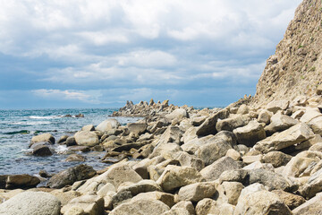 Fototapeta na wymiar sharp jagged basalt rocks on the sea coast