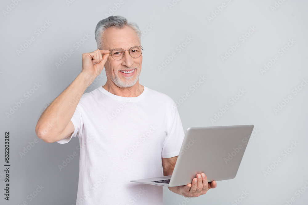 Poster Portrait of positive person arm touch eyewear hold netbook look camera isolated on grey color background