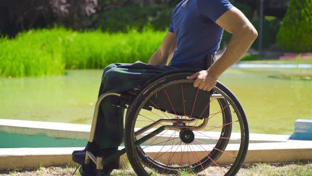 Close-up of disabled person in wheelchair.
Disabled person traveling in a wheelchair in a nature park.
