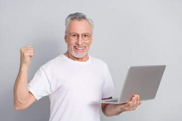 Portrait of delighted positive person raise fist celebrate triumph isolated on grey color background