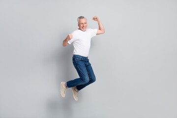 Full length body size view of attractive cheery lucky man jumping rejoicing isolated over grey...