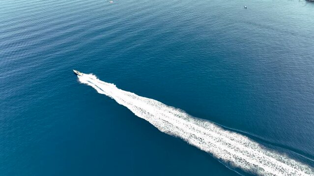 Drone view of a  Luxury boat the blue clear waters. Top view of a fast movement  white boat sailing to the blue sea. Large speed boat moving at high speed. Travel - image.