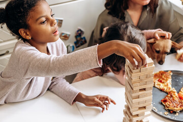 A group of multiage and multiethnic people playing  game on a table at home.Board games concept.Time together.Stay home concept.Selective focus,close up.