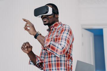 Naklejka na ściany i meble African american man in vr glasses, interact with virtual augmented reality, play online video game