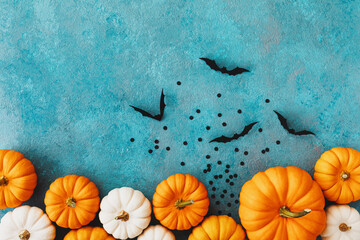 Halloween holiday background with party decorations of pumpkins and bats on white table top view....