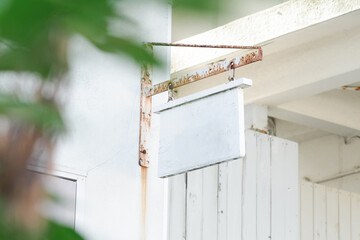 ショップの軒先に吊るされた白い木製看板　コピースペース - obrazy, fototapety, plakaty