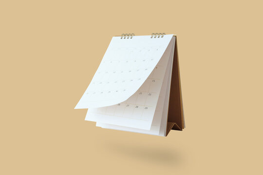White paper desk calendar flipping page mockup isolated on brown background