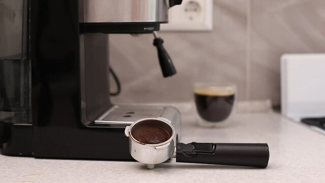 close-up of a woman wiping the coffee machine with a sponge after making coffee