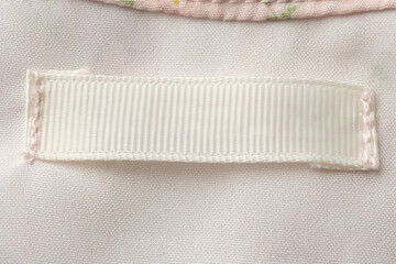 Obraz na płótnie Canvas Blank laundry care clothes label on fabric texture background