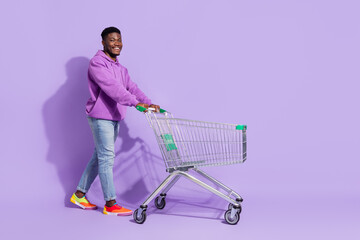 Full length body size view of attractive cheerful guy buying goods copy space isolated over bright...