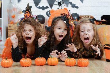 Happy Halloween! a group of children in suits and with pumpkins in home