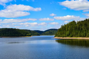 dam inbetween a forest in germany with blue sky and clouds