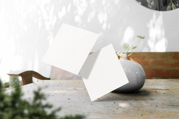 Clean minimal square flyer mockup floating on wooden top table with mini vase and plant