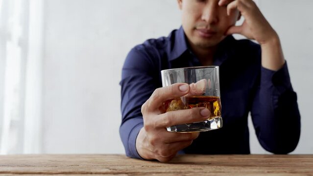 Alcoholism concept. Young man drinking alcohol too much. drunk asian man hold whisky glass addicted alcohol need therapy.