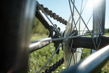 Close-up detail of a bicycle parked in a meadow, against the backdrop of the sun and blue sky....