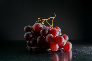 Racimo de uvas de la vendimia sobre fondo oscuro. Espacio para texto. 