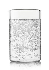 Mineral sparkling water with bubbles in highball glass on white.