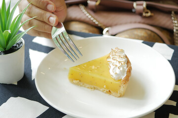 women hand eating lemon tart top view 