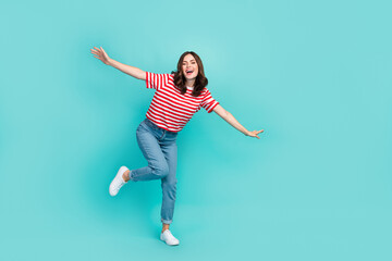 Fototapeta na wymiar Full length photo of cheerful pretty lady imagine dream trip plane wing flight empty space isolated on cyan color background