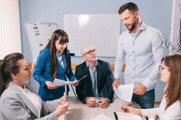 A team of business people are discussing the project together in the office.