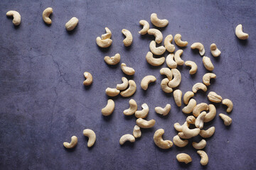 Fototapeta na wymiar top view of cashew nuts spilling on black background 