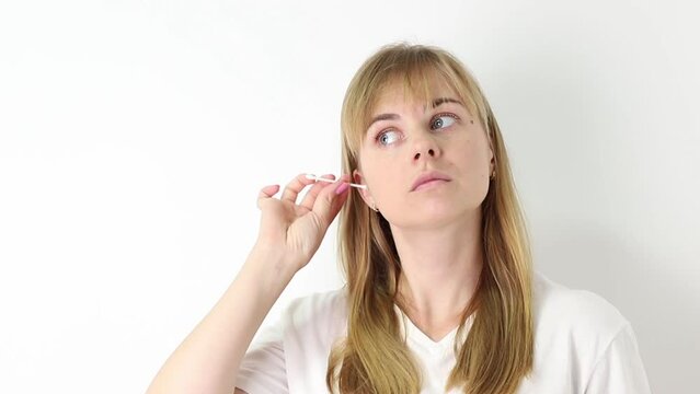 woman cleaning her ears with a wooden stick