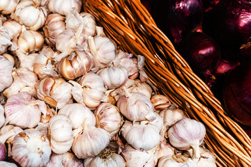 Fresh garlic in a wicker basket on the counter in the store. Close-up
