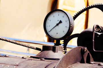Pressure gauge on an old steam boiler. Steam-powered machines and engines. Rusty, obsolete equipment. Close-up