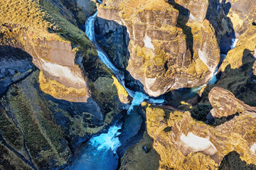  Overhead view of the Fjadrargljufur canyon in South-East Iceland. The canyon is 100 metres deep and runs for 2km. Aerial view of the converging rivers and waterfalls. Drone shot
