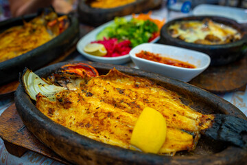Fish dish in Tropic restaurants on the river. Places on the river with tourists in forest, Turkey