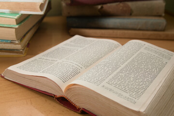 Obraz premium Close-up of an old book open to a random page, around it are other worn books