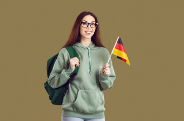 Overjoyed female student in hoodie with backpack and German flag enjoy study abroad. Smiling girl...