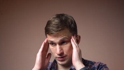 Stressed young man massages his head. migraine. close-up.