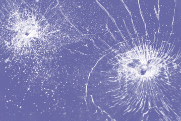 Bullet hole in a veri peri glass on the purple,veri peri color background.closeup.
