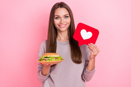 Photo of attractive girl hand hold cheeseburger paper like card isolated on pink color background - Powered by Adobe
