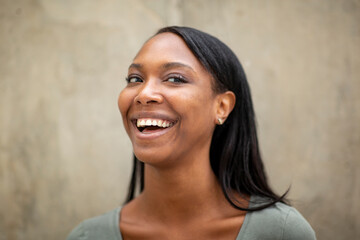 Black woman laughing while looking away outdoors