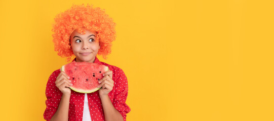 happy child in fancy orange hair wig hold fresh ripe water melon slice fruit, organic food. Summer girl portrait with watermelon, horizontal poster. Banner header with copy space.
