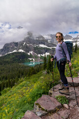 Woman hiker takes a moment to enjoy the scenery along the Grinnell Glacier Hike in Glacier National...