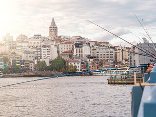 Fototapeta na wymiar Travel to Turkey. People fishing from Galati bridge with many fishing rods side view in Bosporus bay, Istanbul, Turkey