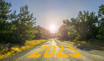 Happy New Year 2023 anniversary. Transition from 2022 to new year. Golden sunrise on empty road. New year concept with the year 2023 on road. High resolution photo for large displays, print, banners.