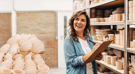 Cheerful female ceramist thinking of new ideas for her store
