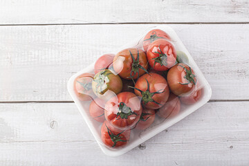 tomatoes packed in a plastic container on white