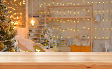 Christmas background. Empty wooden table on the background of a Christmas tree and a blurred children's room.Ready for product montage. Copy space.Mockup.