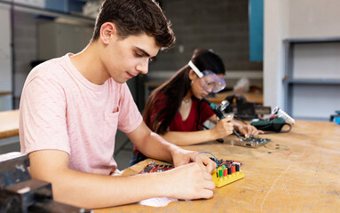 Diverse young high school students learning in science robotics or electronic engineering class