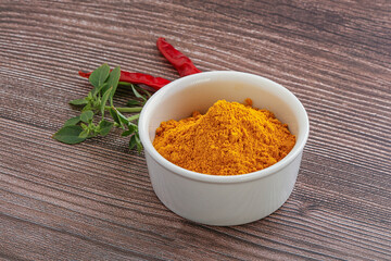 Yellow vibrant curcuma powder in the bowl