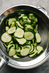 Straining excess liquid from cucumbers