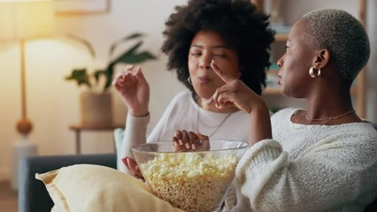 Friends on sofa with popcorn, watching tv, movie or television series together in living room. Black woman with friend relax, eating corn snack while watching film or tv on couch in home lounge - Powered by Adobe